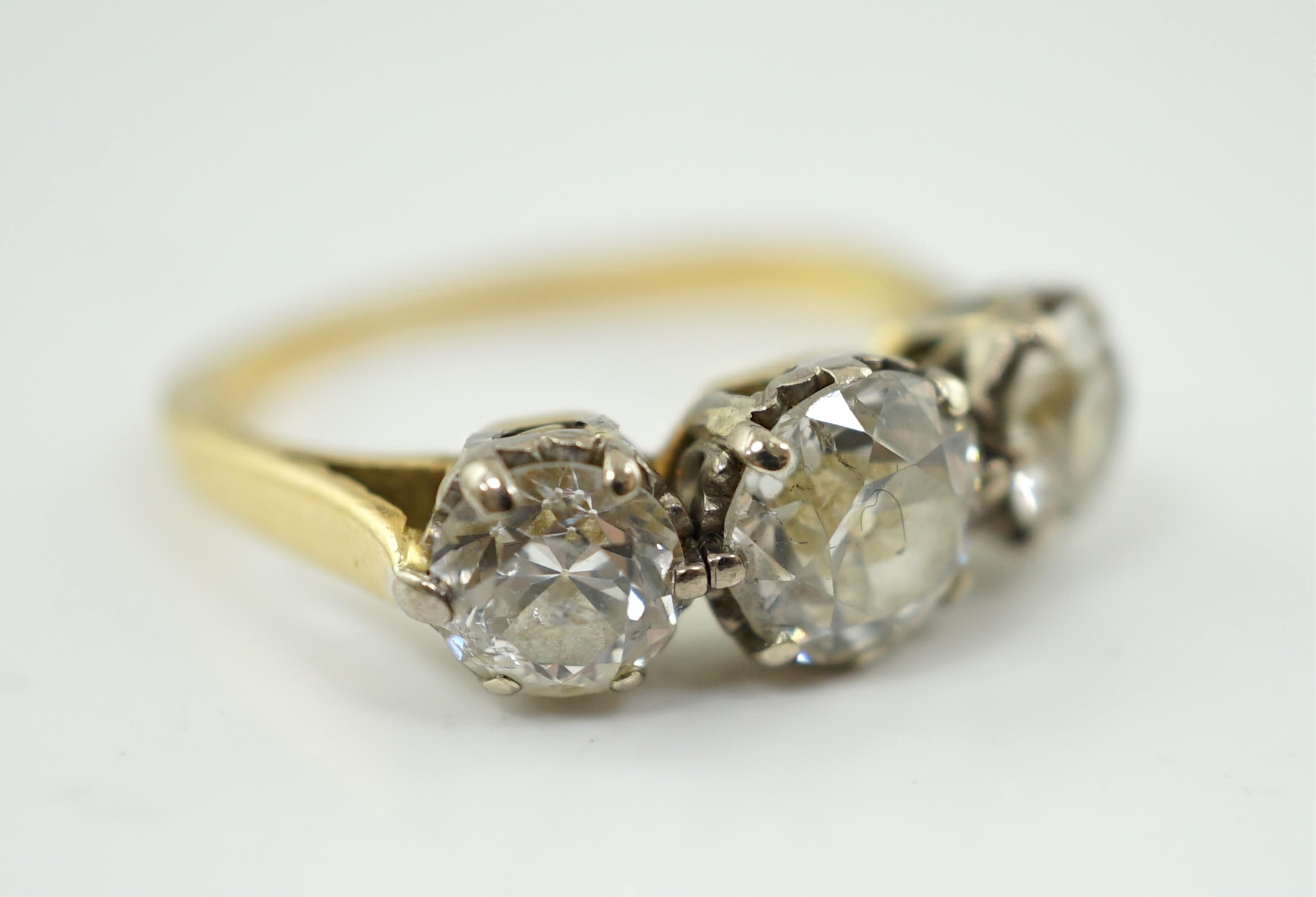 An unmarked gold and three stone diamond set ring